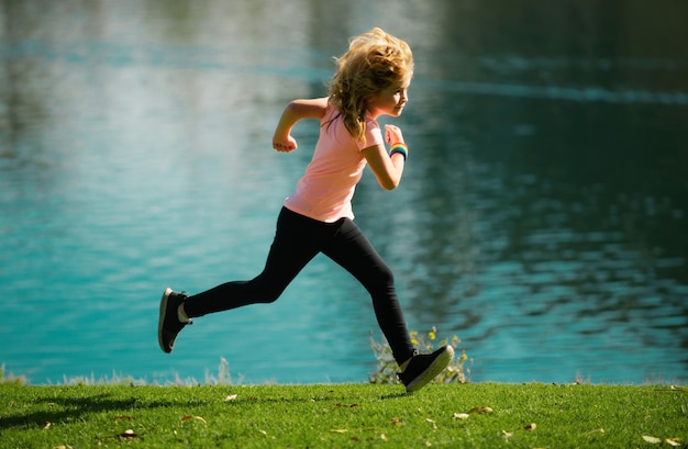 Zdjęcie chłopiec biegający na świeżym powietrzu, dziecko biegające w letnim parku, poranny bieg