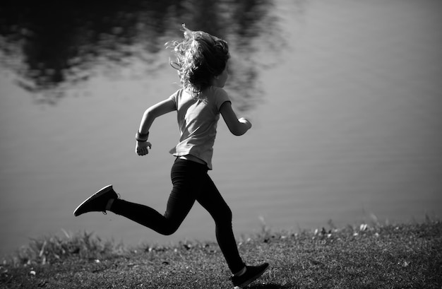 Zdjęcie chłopiec biegający w parku na świeżym powietrzu, dzieci uprawiające sport, szczęśliwe, aktywne dzieci biegające na wolności, biegające wiosną