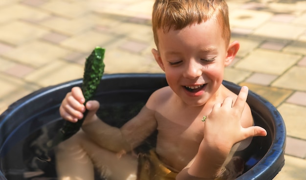 Chłopiec dotyka owada modliszki w letni dzień w wiejskiej koncepcji wiejskiej letniej aktywności