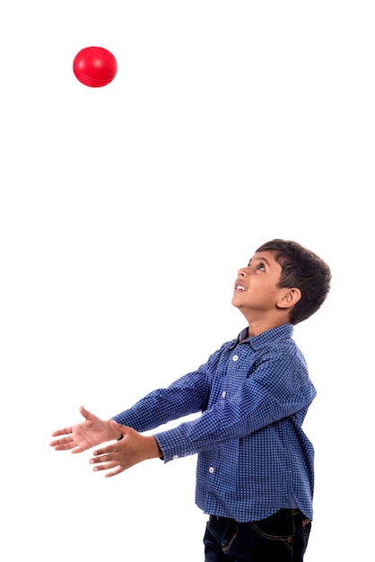 Chłopiec dziecko bawi się piłką na białej ścianie