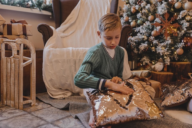 Chłopiec dziecko dekorowanie choinki w domu. Rodzina z dziećmi świętuje ferie zimowe. Dzieci dekorują salon i kominek na Boże Narodzenie.