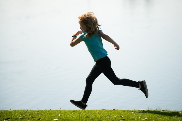 Chłopiec dziecko jogging w parku na świeżym powietrzu dzieci sport szczęśliwe aktywne dzieci bieganie na świeżym powietrzu bieganie wiosną pa