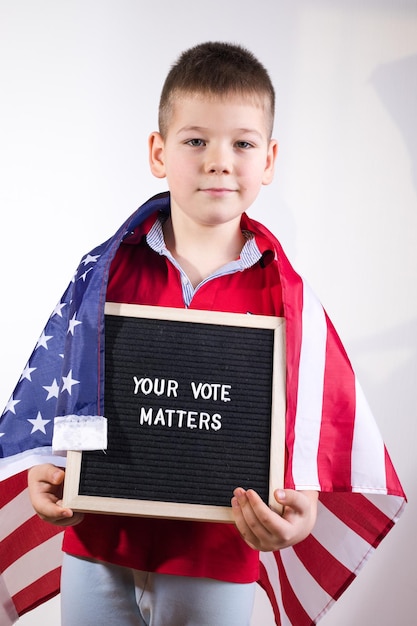 Chłopiec Dziecko Z Amerykańską Flagą Trzymając Tablicę Z Tekstem Twój Głos Ma Znaczenie Na Białym Tle
