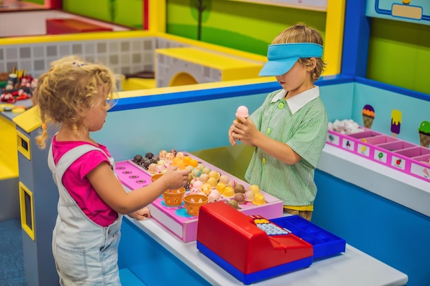 Chłopiec i dziewczynka bawią się w zabawkowej kuchni, robiąc zabawkowe lody