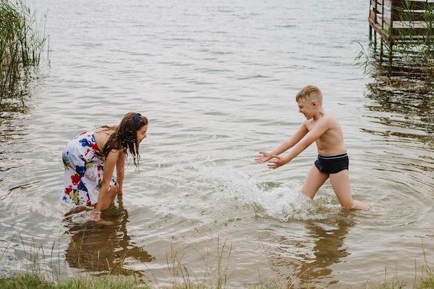 Zdjęcie chłopiec i dziewczynka bawić się w wodzie na brzegu jeziora. wakacje.