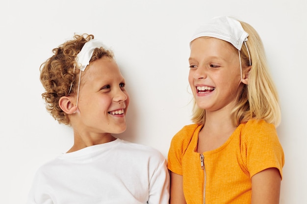 Chłopiec i dziewczynka w medycznej masce zabawy na białym tle niezmienione