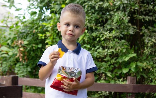 Chłopiec jedzący chipsy selektywnie skupiający się na przyrodzie