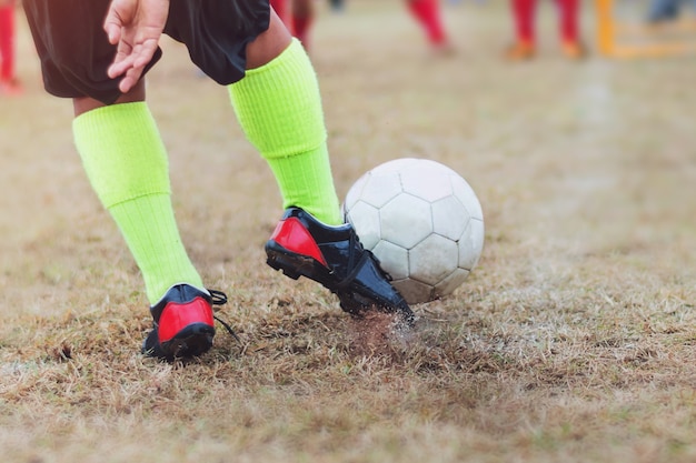 Chłopiec kopnięcie futbolowa piłka nożna na sporta polu