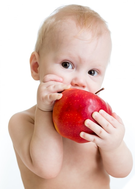 Zdjęcie chłopiec łasowania jabłko, odizolowywający na bielu