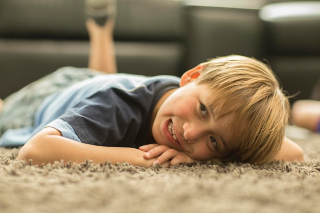 Zdjęcie chłopiec leżący na dywanie w domu