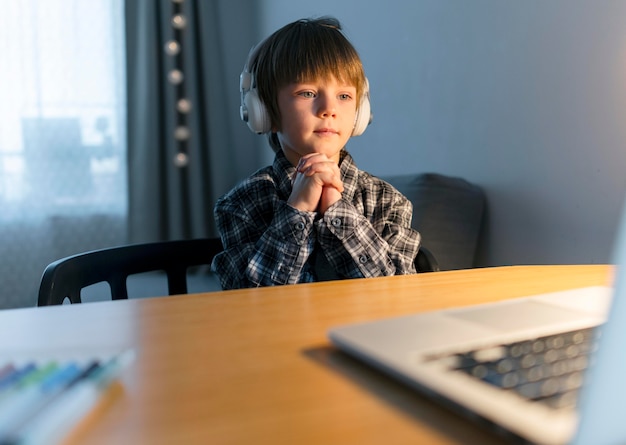 Zdjęcie chłopiec mający wirtualne kursy na laptopie