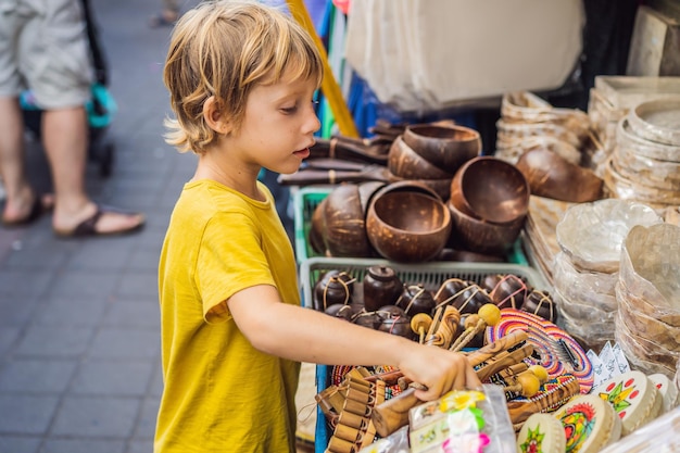 Chłopiec na targu w ubud bali typowy sklep z pamiątkami sprzedający pamiątki i rękodzieła z bali w