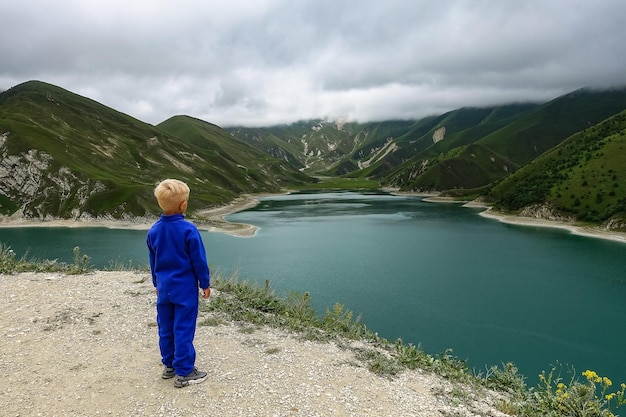 Chłopiec na tle jeziora Kezenoyam w górach Kaukazu w Czeczenii Rosja czerwiec 2021