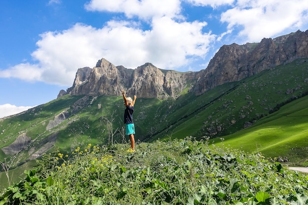 Chłopiec na tle zielonego krajobrazu przełęczy Aktoprak na Kaukazie Rosja czerwiec 2021