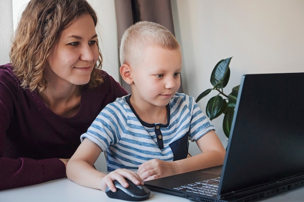 Chłopiec Pracuje Na Komputerze Wraz Z Jego Mamą W Domu. E-lekcje, Edukacja Dla Dzieci.