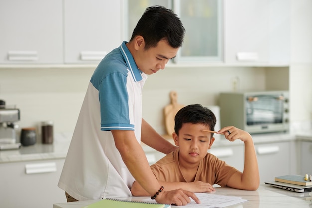Chłopiec proszący ojca o pomoc z pracą domową