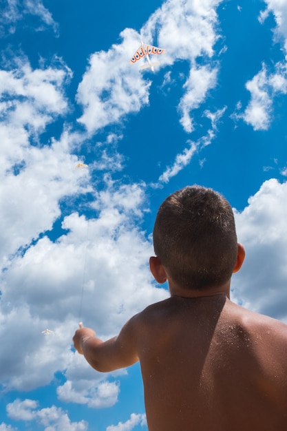 Chłopiec puszcza latawiec na plaży