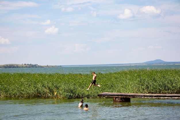 Chłopiec skoki w wodzie jeziora na letnie wakacje.