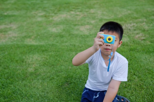 chłopiec strzelanie aparat na trawie
