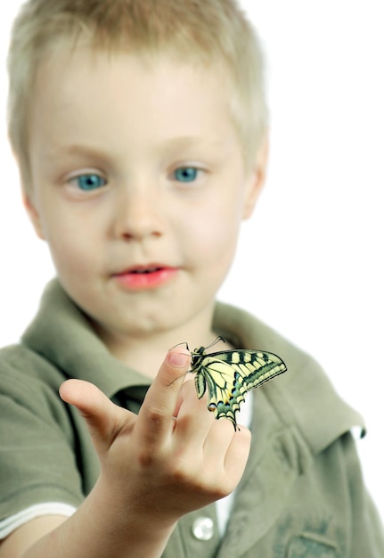 Chłopiec trzyma motyla, na którym jest słowo motyl.