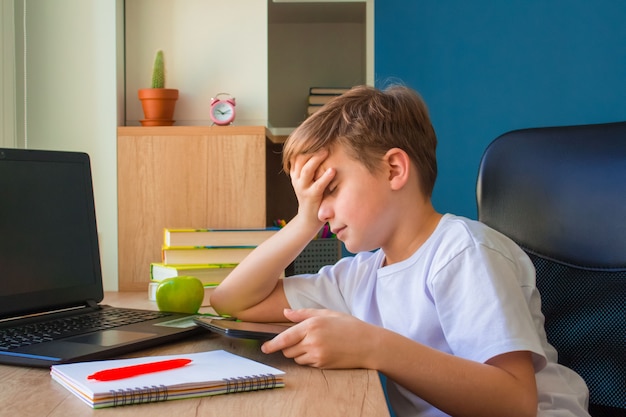 Chłopiec uczy się w Internecie za pomocą tabletu