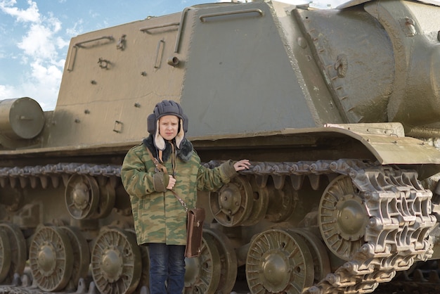 Chłopiec w mundurze tankowca w pobliżu czołgu zimą w czasie pokoju w Rosji na wakacjach