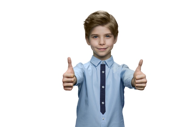 Chłopiec w niebieskiej koszuli pokazujący dobrze obiema rękami na białej ścianie