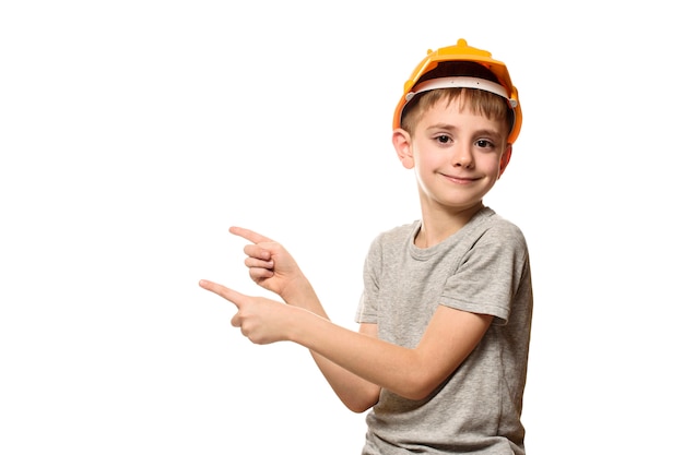 Chłopiec w pomarańczowym hełmie budowlanym