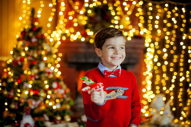 Chłopiec w stroju noworocznym przy kominku w sylwestra.