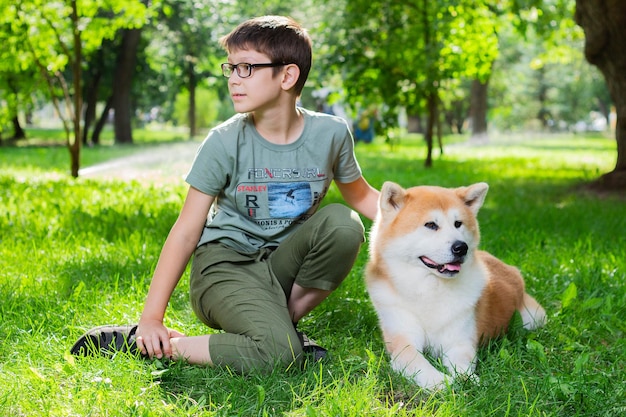 Chłopiec z japońskim psem Akita inu w parku