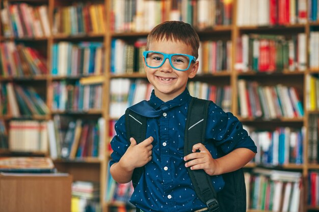 Chłopiec z plecakiem w bibliotece