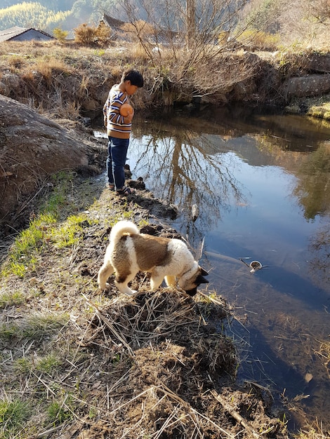 Zdjęcie chłopiec z psem nad jeziorem