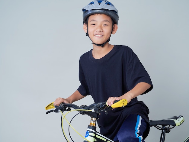 Zdjęcie chłopiec z rowerem na jasnym tle