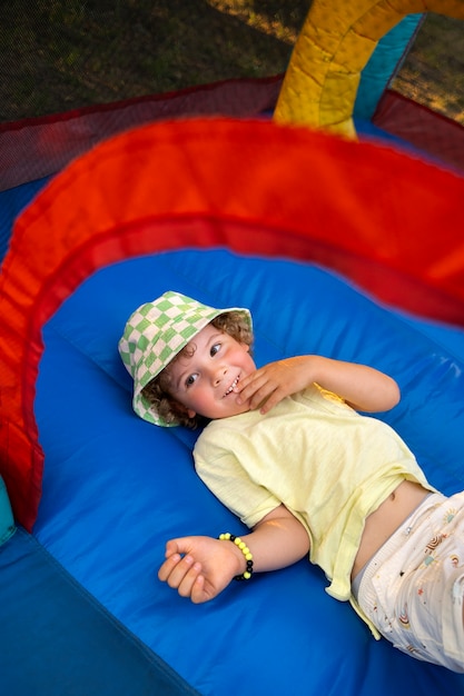 Zdjęcie chłopiec z wysokim kątem bawi się w bounce house