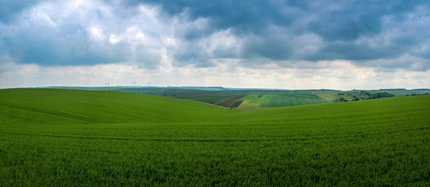 Zdjęcie chmury burzowe nad polem pszenicznym malownicze wzgórziste pole i krajobraz wioski na horyzoncie