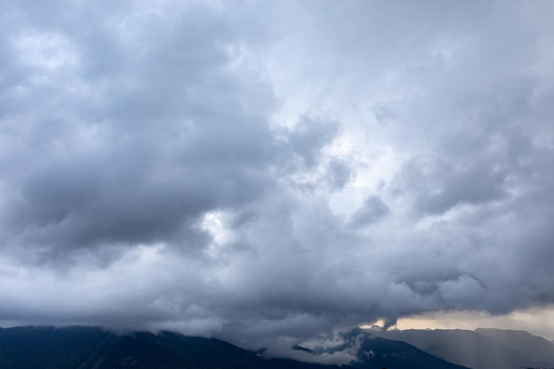 Zdjęcie chmury cumulus i poranna mgła nad górami wczesnym letnim rankiem przed burzowe niebo