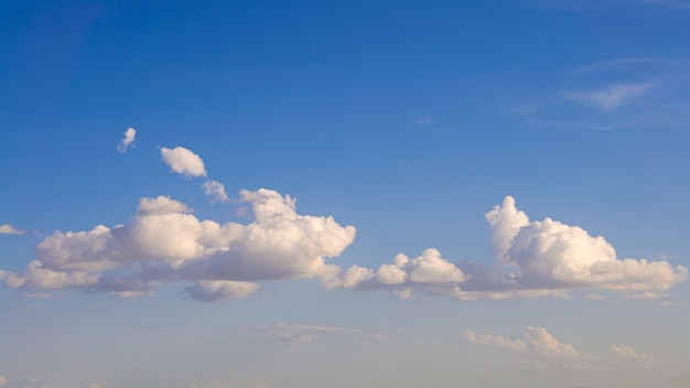 Chmury Cumulus z błękitnym niebem w słoneczny dzień lata. Piękny cloudscape jako panorama tła przyrody. Cudowna pogoda naturalnego światła dziennego z unoszącą się białą chmurą, tworzącą abstrakcyjny kształt