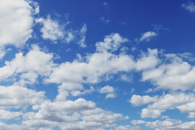 Chmury na niebieskim niebie. Białe, puszyste chmury na niebieskim niebie. Charakter tła. Cumulus tekstury unoszący się na niebieskim niebie. Koncepcja tła. Środowisko, atmosfera. Miejsce na napis lub logo