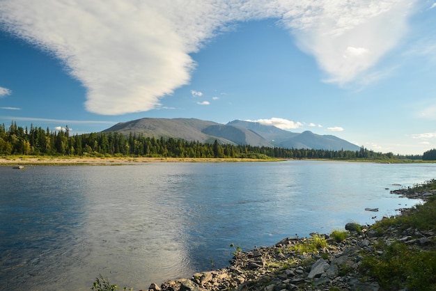 Chmury nad górą Telposiz odbijają się w rzece Schugor