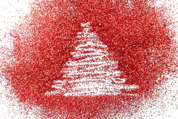 Choinka narysowana palcem na błyszczącym czerwonym tle konfetti