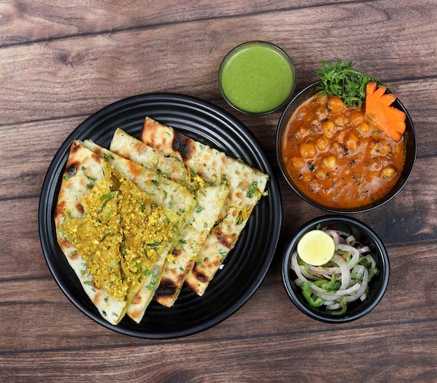 Chole Kulcha Clay pieczony nadziewany Naan podawany z channa masala lub chole masala typowym posiłkiem Amritsar India izolowanym na rustykalnym drewnianym tle selektywne focus