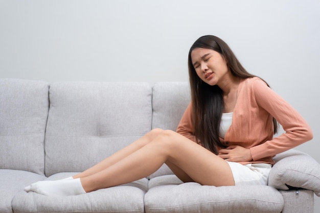 Chorą Azjatka cierpiąca na ostry ból brzucha z powodu menstruacji PMS