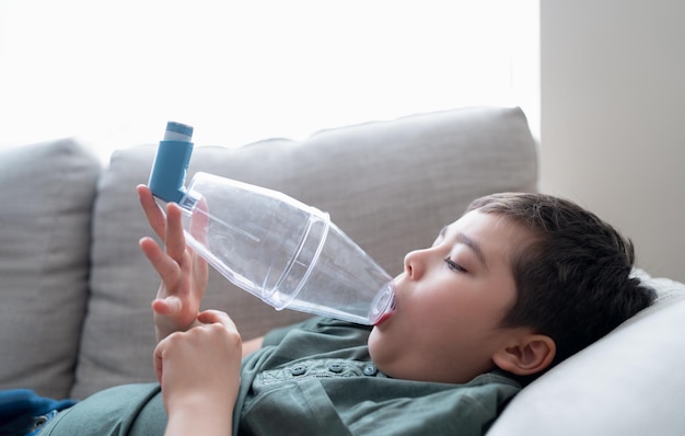 Chore dziecko używające inhalatora astmy na alergieBiedny chłopiec zmęczony kaszlem w klatce piersiowej trzymający inhalator spacerPróbowałem Dziecko mające alergię na astmę