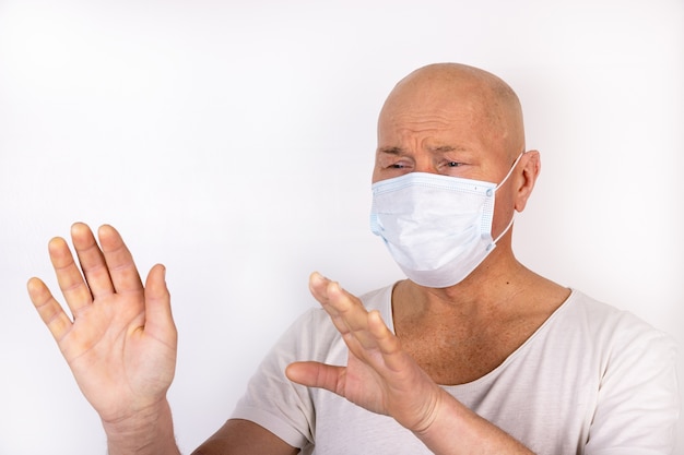 Chory mężczyzna w masce medycznej stoi na białym