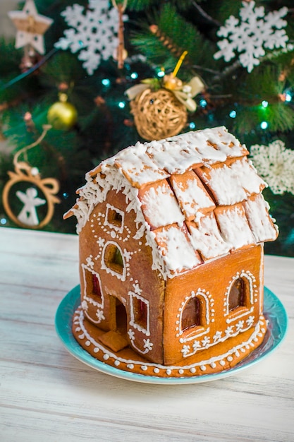 Zdjęcie christmas gingerbread house z glazury na drewnianym stole