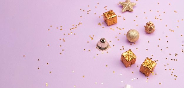 Christmas party background Zbliżenie zdjęcia złotych ozdób choinkowych na fioletowym tle Kopiuj przestrzeń