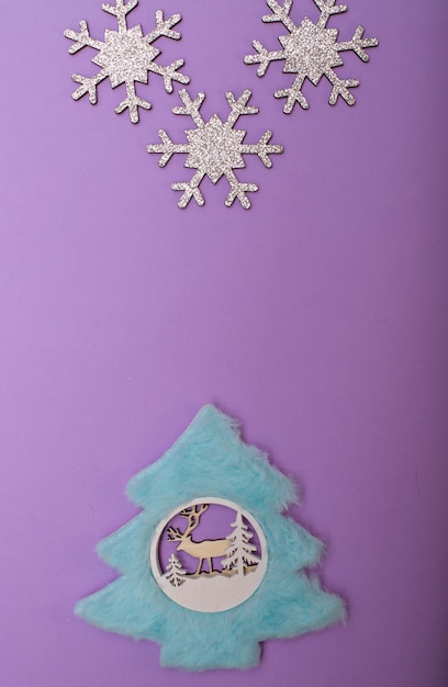 Christmass flatlay choinka z niebieskim futrem i srebrzystymi płatkami śniegu.