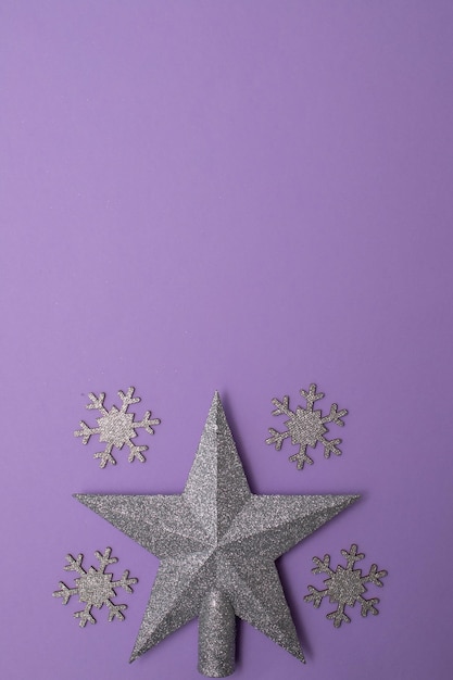 Christmass flatlay zabawki choinkowe i srebrna gwiazda wystrój na fioletowym tle.