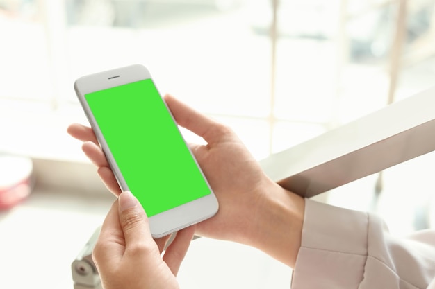 Chroma key compositing Kobieta trzymająca smartfon z zielonym ekranem zbliżenie w pomieszczeniu Makieta do projektowania