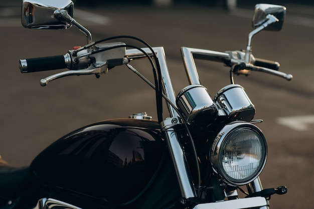 Chromowana kierownica i reflektory motocykla, zbliżenie Stylowy motocykl customowy chopper z chromowanymi detalami. Miękka selektywna ostrość.